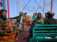 Taliban fighter shouts on the pirate ship ride at a fairground in western Kabul, as his armed comrades cackle and whoop on board the rickety attraction. (Photo by WAKIL KOHSAR / AFP) / TO GO WITH: AFGHANISTAN-CONFLICT-FAIRGROUND, SCENE BY JAMES EDGAR - TO GO WITH: Afghanistan-conflict-fairground, SCENE by James EDGAR