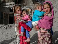 In this picture taken on October 3, 2021, Hazara ethnic children stand on a cliff pockmarked by caves where people still live as they did centuries ago in Bamiyan. 