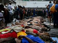 People line up bodies on Sao Lucas Square of the Vila Cruzeiro favela at the Penha complex in Rio de Janeiro, Brazil, on October 29, 2025, in the aftermath of Operacao Contencao (Operation Containment). AFP Death toll in Brazil’s Rio police raid rises to 132