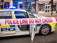 شريط الشرطة وسيارة شرطة في موقع جريمة خطيرة في لندن - المملكة المتحدة