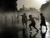 أطفال يلعبون كرة القدم بينما يبردون أجسامهم في نافورة مياه، في ظل موجة حر تضرب إسبانيا
