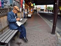 Elderly Japanese Man sitting alone in the street