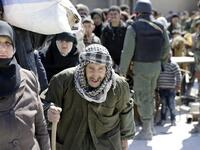 Syrian civilians, evacuated from rebel-held areas in the Eastern Ghouta, gather at a school in the regime-controlled Hosh Nasri, on the northeastern outskirts of the capital Damascus on Mar.16, 2018, ahead of being relocated to other areas. (LOUAI BESHARA / AFP)