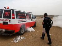 A Palestinian protester covers his face as he walks near an ambulance with incoming teargas canisters fired by Israeli forces during clashes following a demonstration near the border with the Gaza strip east of Jabalia on May 4, 2018, on the sixth straight Friday of mass demonstrations. (MOHAMMED ABED / AFP)