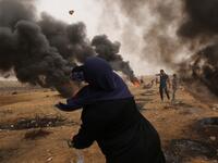 A Palestinian woman protester hurls stones towards Israeli forces during clashes along the border with the Gaza strip east of Gaza City on May 4, 2018, on the sixth straight Friday of mass demonstrations calling for the right to return to their historic homelands. (MAHMUD HAMS / AFP)
