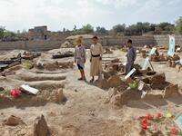 Yemeni children stand by the graves of schoolboys who were killed while on a bus that was hit by a Saudi-led coalition air strike on the Dahyan market in August, at a cemetery in the Huthi rebels' stronghold province of Saada on September 4, 2018. 
STRINGER / AFP