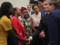 A woman reacts as British Prime Minister Theresa May (L), French President Emmanuel Macron (C) and Canadian Prime Minister Justin Trudeau (R) greet a group of women ahead the start of a Girl Education event at UN headquarters during the General Assembly of the United Nations in New York, September 25, 2018. 
AMR ALFIKY / AFP / POOL