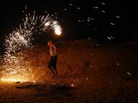 A Palestinian protester from a group calling themselves the "night confusion units" waves a sparkler near the Gaza-Israel border east of Rafah in the southern Gaza Strip, on September 26, 2018. 
SAID KHATIB / AFP