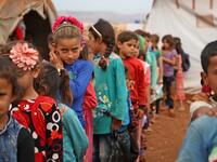 Syrian children who fled with their families from the northern countryside of Hama, line up in the yard of the makeshift school of "Zuhur al-Mustaqbal" (in Arabic "Flowers of the Future") in al-Jeneinah camp for displaced people in the village of Atme, in Syria's mostly rebel-held northern Idlib province, on October 1, 2018. Aaref WATAD / AFP