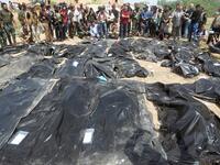 Iraqis mourn near body-bags containing the remains of people believed to have been slain by jihadists of the Islamic State (IS) group lying on the ground at the Speicher camp in the Iraqi city of Tikrit. (AHMAD AL-RUBAYE / AFP)