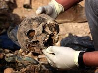 Members of the Yazidi minority search for clues, that might lead them to missing relatives in the remains of people killed by the Islamic State (IS) jihadist group. (Safin HAMED / AFP)