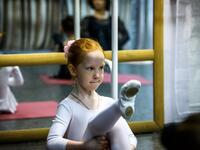 A girl attends a class at a ballet studio in Moscow on November 22, 2018. In a small studio in northern Moscow, parents and grandparents sit in a corridor waiting for children as young as three to finish their ballet class. 
Mladen ANTONOV / AFP