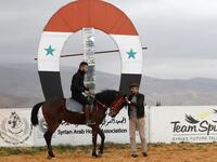A Syrian man prepares to ride a horse at a track in the town of Dimas, west of the Syrian capital Damascus LOUAI BESHARA / AFP