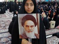 An Iranian girl holds a poster of Iran's late founder of the Islamic Republic, Ayatollah Ruhollah Khomeini. STR / AFP
