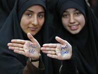 Iranian girls show their hands with a slogan reading in Farsi: "Ready to sacrifice my self for the leader" at the tomb of Iran's late founder of the Islamic Republic, Ayatollah Ruhollah Khomeini. STR / AFP