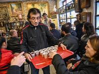A man serves tea as auctioneer Ali Tuna (back R) shows items to the audience at an auction house in Istanbul's Balat district.
OZAN KOSE / AFP