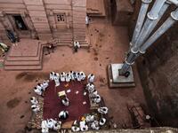 Ethiopian Orthodox devotees gather near the pillar of a shelter that protects the rock-hewn structure from erosion of the church of Saint Emmanuel in Lalibela, Ethiopia 
EDUARDO SOTERAS / AFP