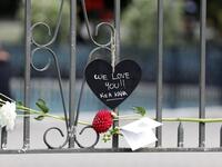 A flower is placed on the railing with a message for the victims of the mosques attacks at the Botanical Garden in Christchurch 
Tessa BURROWS / AFP