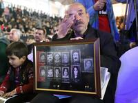 An Iraqi-Kurd carries portraits of relatives during a gathering in Halabja 
Shwan MOHAMMED / AFP