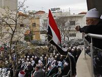 Druze residents of the Golan Heights wave Syrian flags as they protest against the backing of Israel's capture of the Golan Heights by the US president, in the village of Majdal Shams in the Israeli-annexed territory on March 23, 2019. 
Jalaa MAREY / AFP