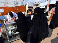Women shop  from a stall in the souk or market of Al-Hol camp for displaced people in northeastern Syria
GIUSEPPE CACACE / AFP