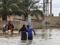 An Iranian family walks through a flooded street in a village around the city of Ahvaz, in Iran's Khuzestan province
Mehdi Pedramkhoo / TASNIM NEWS / AFP