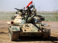 A picture taken on October 6, 2017 shows a tank belonging to the Hashed al-Shaabi (Popular Mobilisation) paramilitaries advancing towards villages between the northern Iraqi cities of Hawija and Kirkuk
AHMAD AL-RUBAYE / AFP