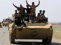 Members of the Hashed al-Shaabi (Popular Mobilization) paramilitaries flash the victory gesture as they ride atop an infantry-fighting vehicle during the advance towards villages between the northern Iraqi cities of Hawija and Kirkuk on October 6, 2017
AHMAD AL-RUBAYE / AFP