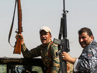 Members of the Iraqi forces pose with their rifles as they ride in the back of a pick-up truck during the advance towards villages between the northern Iraqi cities of Hawija and Kirkuk on October 6, 2017
AHMAD AL-RUBAYE / AFP