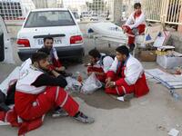 Iranian Red Crescent paramedics eat and rest during a break from tending to quake victims and survivors.

(ATTA KENARE / AFP)
