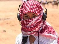 A girl in the Jordanian scarf listens to music in the Wadi Rum desert (Twitter) 