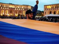 Protesters holding an Armenian flag in the main square in Yerevan  (AFP/File Photo)	