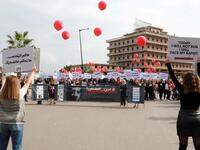 Activists hold banners against sexual assaults during the 16th edition of the Beirut Marathon on November 11, 2018. 
ANWAR AMRO / AFP