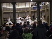People look at whirling dervishes performing during a ceremony marking the anniversary of the death of Jelaleddin Mevlana Rumi, Sufi mystic, poet and founder of the sufism on December 16, 2018 at Galata Mevlihanesi in Istanbul. 
Yasin AKGUL / AFP