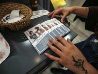 Palestinian fashion designer Yasmeen Mjalli arranges leaflets for her label collection "BabyFist" carrying anti-sexual harassment slogans in her shop in Ramallah 
ABBAS MOMANI / AFP