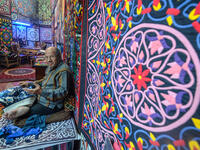 An Egyptian craftsman gestures as he sits while working on a tapestry in his shop in Khayamiya Street, or the Street of Tent-makers, in the old city of the Egyptian capital Cairo 
Mohamed el-Shahed / AFP