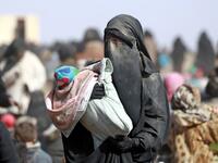 People who fled battles between Syrian Democratic Forces (SDF) and ISIS fighters in the Syrian village of Baghouz, arrive after crossing a desert in the back of a truck to a region controlled by the SFD in the countryside of the Deir Ezzor province. Delil SOULEIMAN / AFP