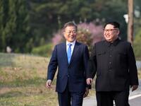North Korea's leader Kim Jong Un (R) and South Korea's President Moon Jae-in (L) walk together after a tree-planting ceremony. Korea Summit Press Pool / AFP