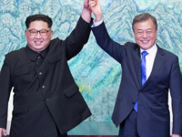 Kim Jong Un (L) and South Korea's President Moon Jae-in (R) raise their jointed hands during a signing ceremony near the end of their historic summit on April 27, 2018. Korea Summit Press Pool / AFP