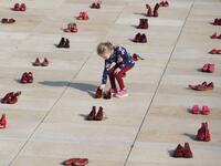 Israelis walk past an installation of red shoes during a rally against domestic violence in the Israeli coastal city of Tel Aviv on December 4, 2018 (Twitter)