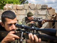 ‘Hewal Dilsad,’ A 26-year old foreign fighter from the US, nick-named by Kurdish fighters, points his sniper gun during clashes with Islamic State (IS) group fighters outside Tal Tamr on April 4, 2015.