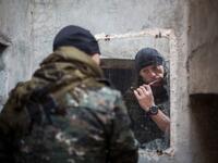 A 33-year old from New Zealand, nick-named by Kurdish fighters as ‘Hewal Welat,’ brushes his teeth on April 17, 2015 just outside Tal Tamr.