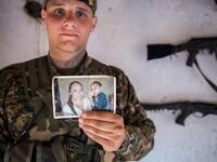 ‘Hewal Dilsad,’ a 26-year old from the US, shows a picture of his wife and son as he poses for a photo in Tal Tamr on April 14, 2015.