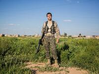 22-year old ‘Hewal Zagros’ from the US poses for a photo on April 14, 2015 on the outskirts of Tal Tamr.