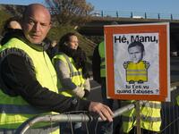 Protestors stand near a picture representing French President Emmanuel Macron while they slow down traffic on a road in Saint-Herblain, near Nantes, western France, on November 18, 2018.
SEBASTIEN SALOM GOMIS / AFP