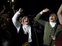 Protesters raise their fists near riot police officers during a demonstration outside the prime minister's office in the capital Amman late on June 3, 2018. 
Khalil MAZRAAWI / AFP