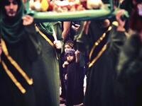  Shiite Muslim boy holds his father's hand during a ceremony (Twitter)