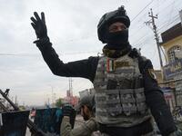 A member of the Iraqi security forces salutes onlookers as he parades in the streets of the Iraqi city of Mosul, during celebrations marking the first anniversary of the country's victory over the Islamic State (IS) group. 
Zaid AL-OBEIDI / AFP
