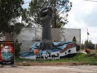 A portrait of the Syrian President Bashar al-Assad stands near a sculpture in the Syrian town of Quneitra, in the Golan Heights on March 26, 2019. The writing in Arabic reads: "The Golan is ours". 
Louai Beshara / AFP