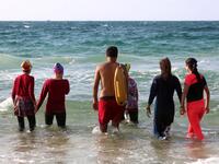 Young Palestinian members of a swimming club, walk into the sea to begin a training session in Beit Lahia. (SAID KHATIB / AFP)